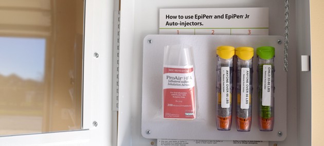 Open AEK cabinet shows inhaler and three epinephrine auto-injectors